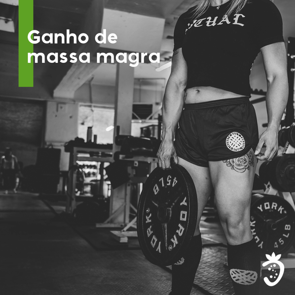 Ganho de Massa Magra Mulher com Peso na Mão ROupa de Academia numa Academia com Equipamentos ao Fundo